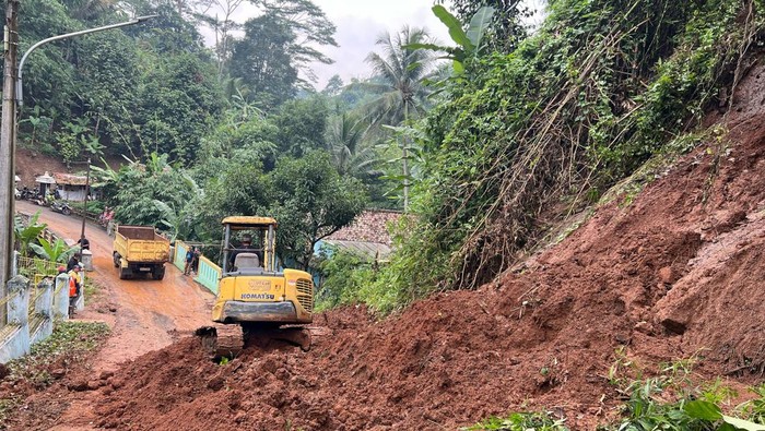 Alat berat bersihkan material longsor yang tutup jalan kampung di KBB