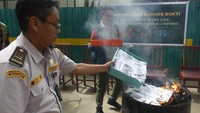 Petugas membakar kupu-kupu yang telah diawetkan saat pemusnahan barang bukti hasil sitaan di kandang konservasi satwa kota Ambon, Selasa (25/02/2025).