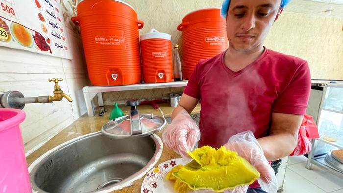 Dubba, Hidangan Penutup Labu Tradisional Yaman yang Terinspirasi oleh Nabi A sweets shop owner holds a piece of cooked pumpkin as he makes the Dubba dessert at his shop in Sanaa, Yemen February 17, 2025. REUTERS/Khaled Abdullah