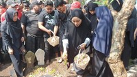 Rahmat Irianto putra menaburkan bunga saat pemakaman alhmarhum ayahnya Bejo Sugiantoro.