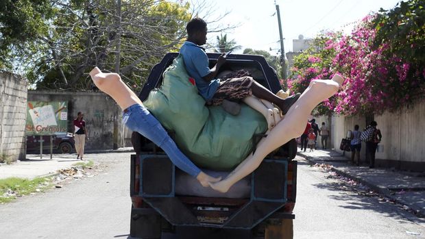 Seorang pria duduk di belakang truk saat penduduk lingkungan Delmas 30 meninggalkan rumah mereka karena kekerasan geng, di Port-au-Prince, Haiti, 25 Februari 2025. (REUTERS/Jean Feguens Regala)