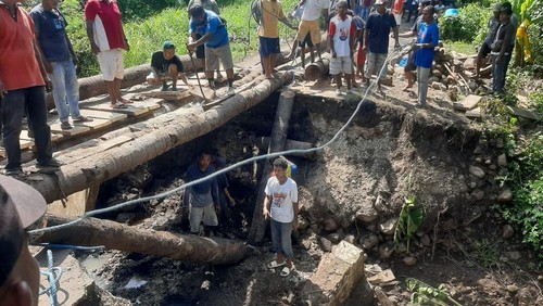 Warga kembali bangun jembatan darurat yang menghubungkan 12 desa di Kecamatan Tanjung Bunga, Flores Timur, NTT, Rabu (26/2/2025). (Foto: Dok. Istimewa)