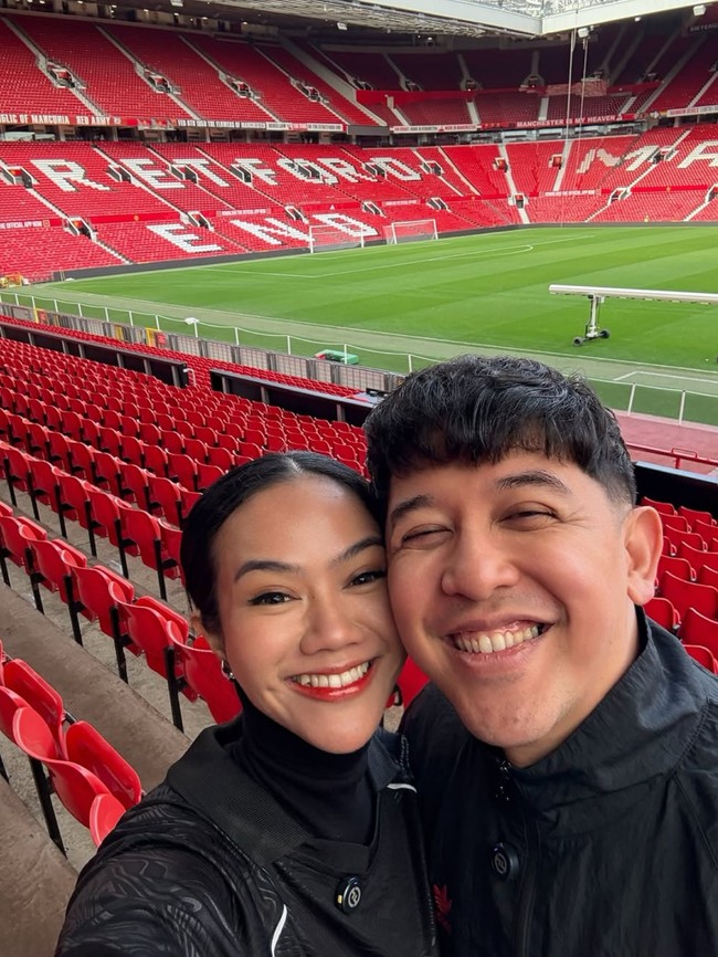 Penyanyi Yura Yunita dan suaminya, Donne Maula, tengah bertolak ke Inggris. Di sana keduanya tampak nonton pertandingan bola Manchester United hingga berkunjung ke Old Trafford Stadium. Foto: Instagram/@yurayunita