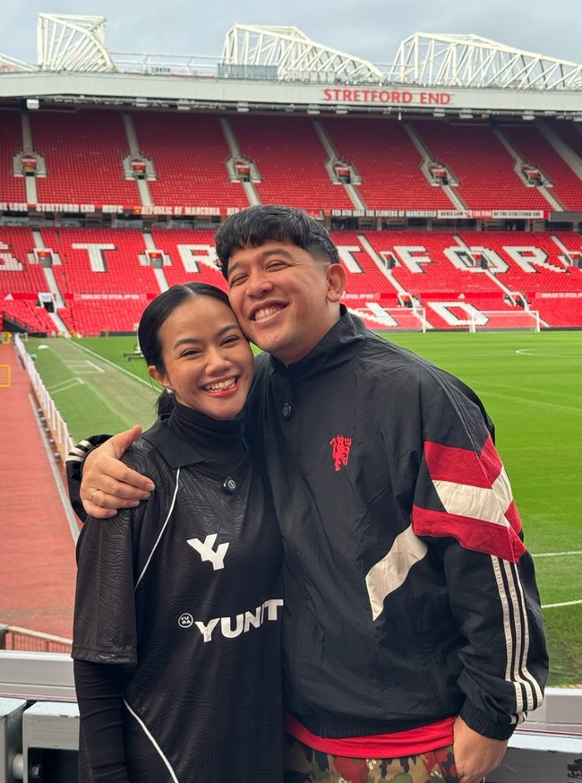 Karena kesukaan suaminya dengan MU, nama Yura kerap diplesetkan menjadi Yura Yunited. Istilah tersebut merujuk pada klub sepak bola Manchester United. Bahkan saat berkunjung ke Old Trafford Stadium, Yura terlihat tampil mengenakan jersey hitam Manchester United dengan nama Yura Yunited. Foto: Instagram/@yurayunita