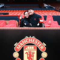 Berpose bersama di Old Trafford Stadium, Yura dan suaminya pamer senyum sumringah mereka. Keduanya juga kompak dengan busana bernuansa hitam. Foto: Instagram/@yurayunita
