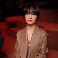 Bintang drama Korea The Glory itu mengenakan silk mini dress dan long pants abu-abu di balik leather coat coklat. Untuk melengkapi penampilannya, Song Hye Kyo menjinjing hand bag Fendi bermotif floral. Foto: Getty Images