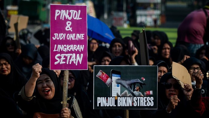 Sejumlah massa aksi menunjukkan poster saat unjuk rasa di Taman Elektrik, Kota Tangerang, Banten, Kamis (27/2/2025). Aksi yang diikuti berbagai organisasi perempuan muslim tersebut sebagai bentuk perlawanan maraknya judi online, pinjaman online dan bank keliling yang  mengancam kesejahteraan keluarga Indonesia. ANTARA FOTO/Putra M. Akbar/foc.