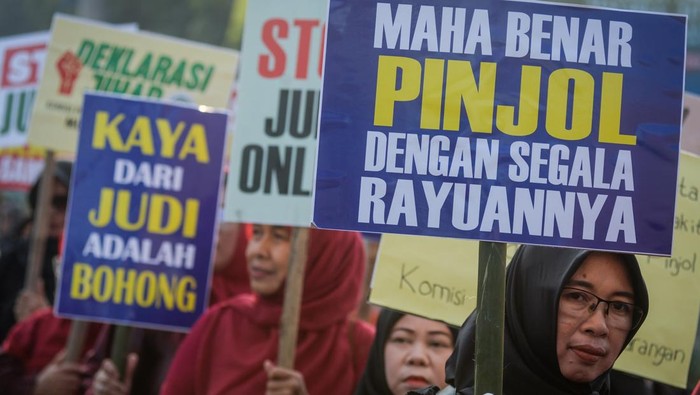 Sejumlah massa aksi menunjukkan poster saat unjuk rasa di Taman Elektrik, Kota Tangerang, Banten, Kamis (27/2/2025). Aksi yang diikuti berbagai organisasi perempuan muslim tersebut sebagai bentuk perlawanan maraknya judi online, pinjaman online dan bank keliling yang  mengancam kesejahteraan keluarga Indonesia. ANTARA FOTO/Putra M. Akbar/foc.
