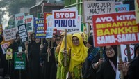 Sejumlah massa aksi menunjukkan poster saat unjuk rasa di Taman Elektrik, Kota Tangerang, Banten, Kamis (27/2/2025).