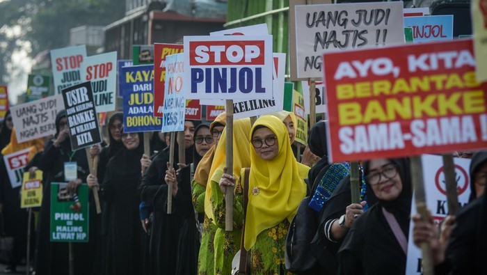 Aksi tolak judol dan pinjol di Tangerang Sejumlah massa aksi menunjukkan poster saat unjuk rasa di Taman Elektrik, Kota Tangerang, Banten, Kamis (27/2/2025). Aksi yang diikuti berbagai organisasi perempuan muslim tersebut sebagai bentuk perlawanan maraknya judi online, pinjaman online dan bank keliling yang mengancam kesejahteraan keluarga Indonesia. ANTARA FOTO/Putra M. Akbar/foc.
