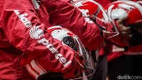 Desain helm dan jaket ini mengusung warna merah dan putih yang jadi identitas perusahaan.