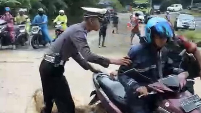Petugas kepolisian membantu pengendara yang melewati akses jalan utama Padang-Pekanbaru, di Nagari Koto Alam, Kecamatan Pangkalan, Kabupaten Limapuluh Kota. (Dok. Satlantas Limapuluh Kota)