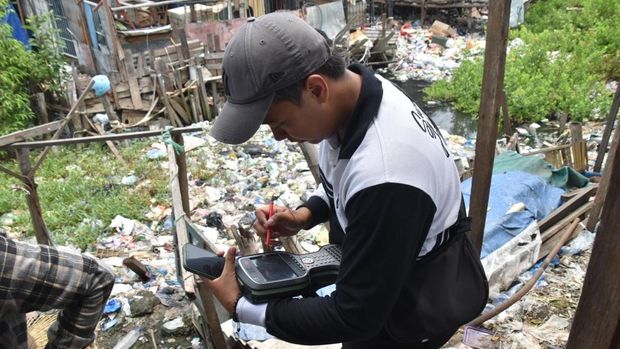 Petugas Pemkot Surabaya mengukur dan menandai bangunan yang akan dibongkar demi normalisasi Sungai Kalianak.