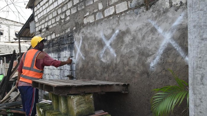 Petugas Pemkot Surabaya mengukur dan menandai bangunan yang akan dibongkar demi normalisasi Sungai Kalianak.