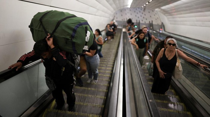 People sit in a subway, in the aftermath of a large power outage in Santiago, Chile February 26, 2025. REUTERS/Pablo Sanhueza       TPX IMAGES OF THE DAY