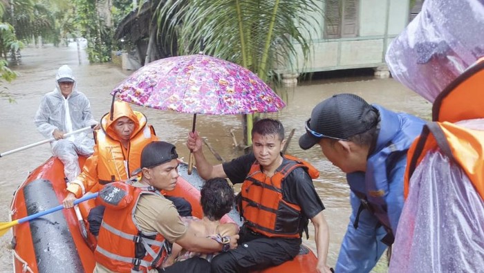 Tim BPBD Limapuluh Kota saat mengevakuasi warga yang terjebak banjir