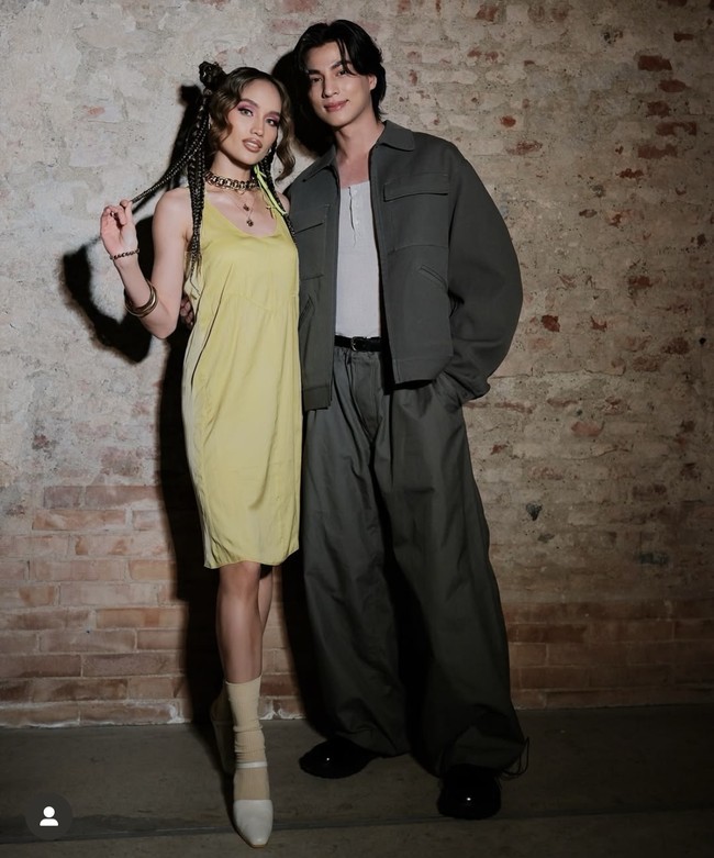 Cinta Laura juga terlihat akrab saat berinteraksi dengan aktor Thailand, Gulf Kanawut yang duduk di sebelahnya selama peragaan busana berlangsung. Bintang TharnType the Series mengenakan jaket dan celana abu-abu dipadu sepatu boots hitam. Foto: dok. Instagram @claurakiehl