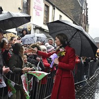 Saat berjalan di sekitar kota, Middleton melepas mantelnya, memperlihatkan busana lainnya. Ia mengenakan turtleneck hitam yang dipadukan dengan jaket hijau zaitun serta rok lipit motif kotak dari Gucci.  (Foto: Ben Stansall/Pool Photo via AP)