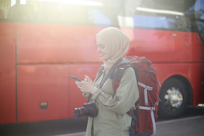 Middle-eastern female tourist traveling at a bus station. About 25 years old, Arab woman.