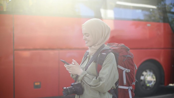 Middle-eastern female tourist traveling at a bus station. About 25 years old, Arab woman.
