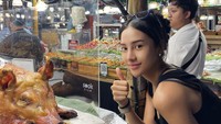 Mengawali 2025, Anya mengunggah foto kulineran di Thailand. Terlihat ia berpose di dekat kepala babi panggang. Foto: Instagam anyageraldine