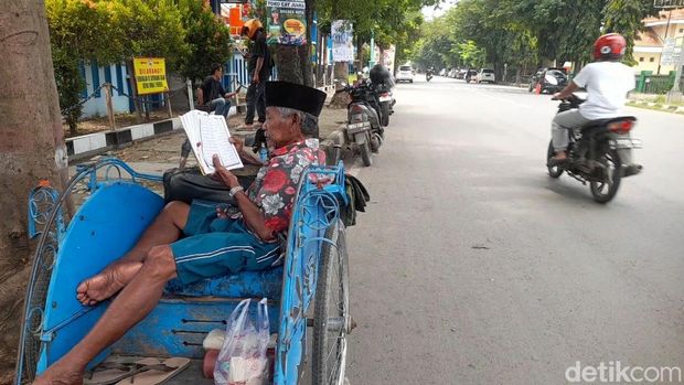 Mbah Tarjo saat mengaji Al-Qur'an di atas becaknya di sela menunggu penumpang di Brebes, Jumat (28/2/2025).