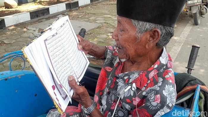 Mbah Tarjo saat mengaji Al-Quran di atas becaknya di sela menunggu penumpang di Brebes, Jumat (28/2/2025).