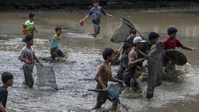 Seorang anak menunjukkan ikan hasil tangkapannya saat tradisi Marak di Situ Citaman, Kecamatan Baros, Kabupaten Serang, Banten, Jumat (28/2/2025). Tradisi Marak atau menangkap ikan bersama-sama saat air di Situ Citaman dikuras itu diikuti ratusan warga dalam rangka menyambut bulan suci Ramadhan 1446 Hijriah. ANTARA FOTO/Angga Budhiyanto/Spt.