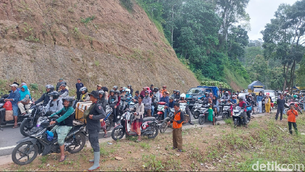 Pengguna jalan mengantre untuk melintasi Jalur Lumajang-Malang yang tertimbun longsor.