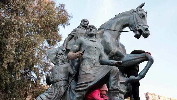 Children climb the Salah Al Din Statue in Damascus, Syria, February 27, 2025. REUTERS/Mahmoud Hassano