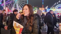 Wulan juga sering membagikan momen liburannya di luar negeri. Salah satunya ketika berada di taman bermain dan tampak menikmati churros. Foto: Instagram @wulanguritno