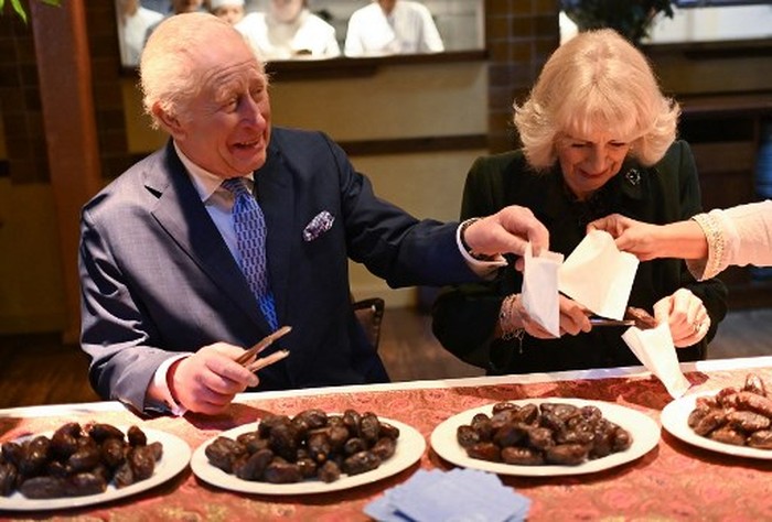 Britains King Charles III and Britains Queen Camilla help pack donation boxes dates at Indian restaurant Darjeeling Express, during a visit ahead of Ramadan, in London on February 26, 2025. (Photo by Eddie Mulholland / POOL / AFP)