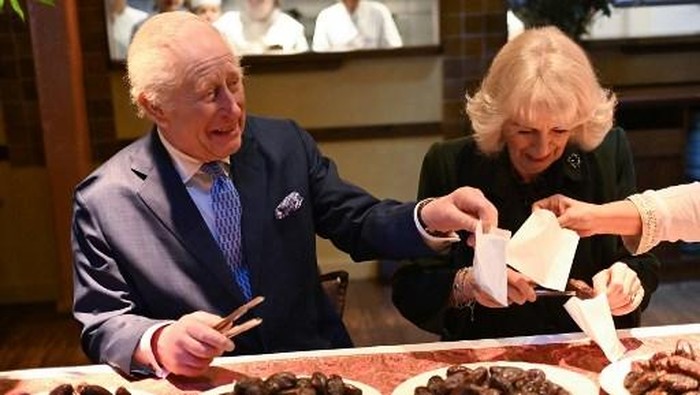 Britains King Charles III and Britains Queen Camilla help pack donation boxes dates at Indian restaurant Darjeeling Express, during a visit ahead of Ramadan, in London on February 26, 2025. (Photo by Eddie Mulholland / POOL / AFP)