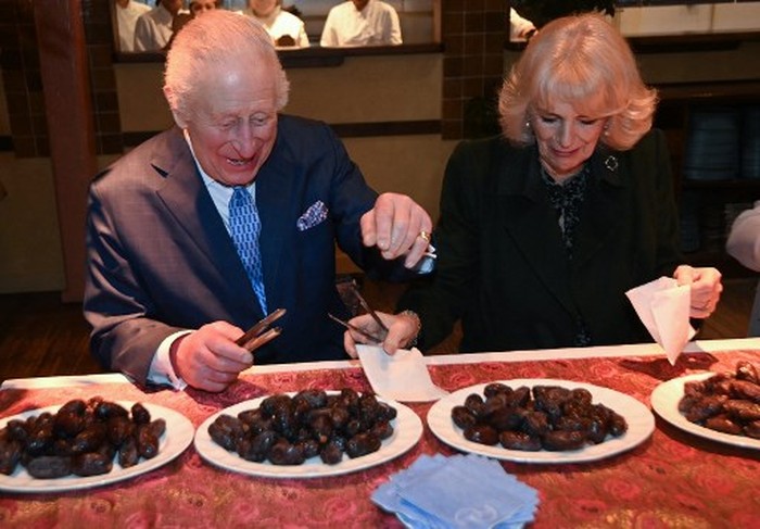 Britains King Charles III and Britains Queen Camilla help pack donation boxes dates at Indian restaurant Darjeeling Express, during a visit ahead of Ramadan, in London on February 26, 2025. (Photo by Eddie Mulholland / POOL / AFP)
