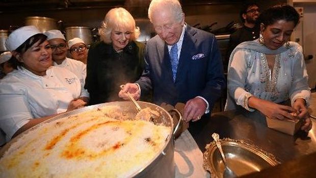 Britain's King Charles III and Britain's Queen Camilla help pack donation boxes dates at Indian restaurant Darjeeling Express, during a visit ahead of Ramadan, in London on February 26, 2025. (Photo by Eddie Mulholland / POOL / AFP)
