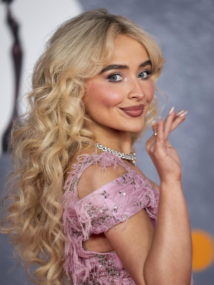 Gaya Sabrina Carpenter di BRIT Awards 2025 Sabrina Carpenter poses for photographers upon arrival at the Brit Awards 2025 in London, Saturday, March. 1, 2025. (Photo by Scott A Garfitt/Invision/AP)