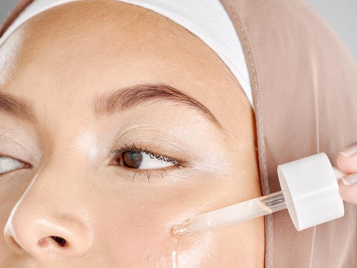 Ilustrasi wanita berhijab pakai skincare