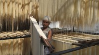 Pekerja melakukan proses penjemuran di bawah sinar matahari.  