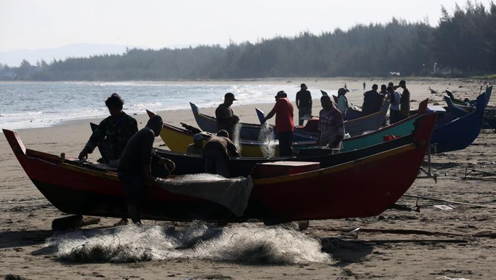Nelayan mengambil ikan yang terperangkap di jaring pada hari pertama melaut bulan Ramadhan di pantai Lam Awe, Aceh Besar, Aceh, Minggu (2/3/2025). Nelayan Aceh mulai beraktivitas kembali menangkap ikan untuk memenuhi permintaan pasar pascalibur meugang Ramadhan seperti yang disepakati dalam hukum adat laut.