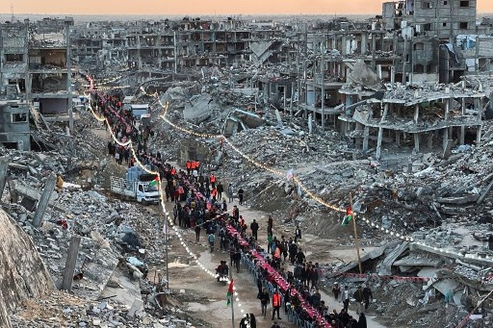 Palestinians gather for a communal iftar, or fast-breaking meal, on the first day of the Muslim holy month of Ramadan, amid building rubble in Rafah in the southern Gaza Strip on March 1, 2025. (Photo by AFP)