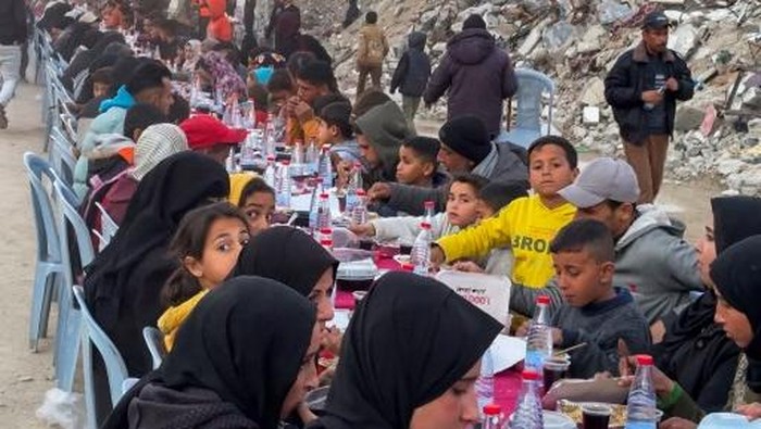 Palestinians gather for a communal iftar, or fast-breaking meal, on the first day of the Muslim holy month of Ramadan, amid building rubble in Rafah in the southern Gaza Strip on March 1, 2025. (Photo by AFP)