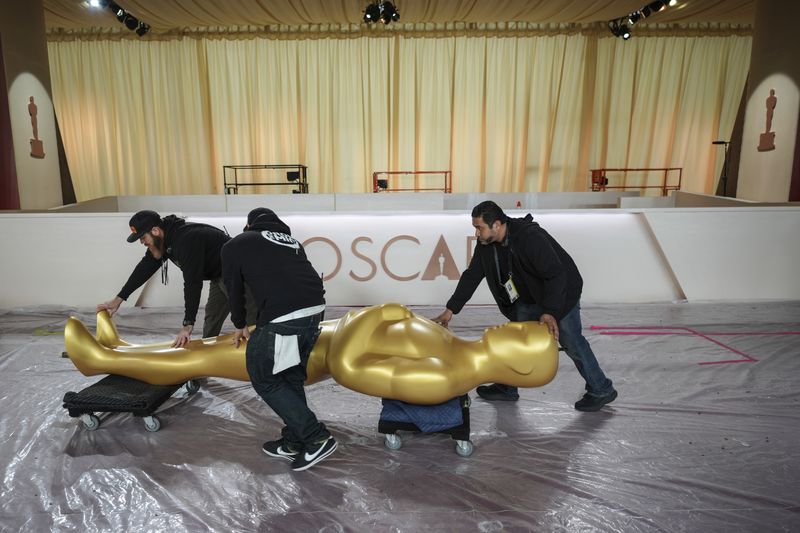 Workers move an Oscar statue through the red carpet area before the 97th Academy Awards in Los Angeles, Saturday, March 1, 2025. (AP Photo/Jae C. Hong)