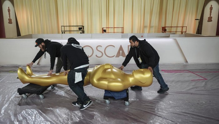 Workers move an Oscar statue through the red carpet area before the 97th Academy Awards in Los Angeles, Saturday, March 1, 2025. (AP Photo/Jae C. Hong)