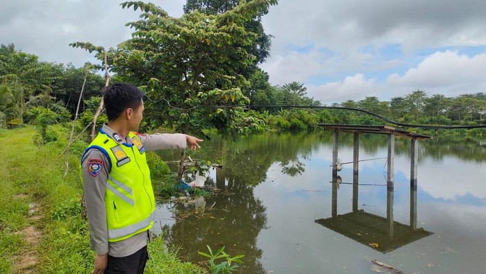 Polisi melakukan penjagaan di kolam ikan di Musi Rawas yang dimasuki buaya