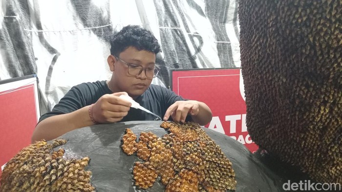 Potongan kulit buah nanas dilem dan dipasang mengikuti kontur tubuh Ogoh-Ogoh karakter raksasa karya ST Adhi Kusuma, Minggu (24/2/2025).