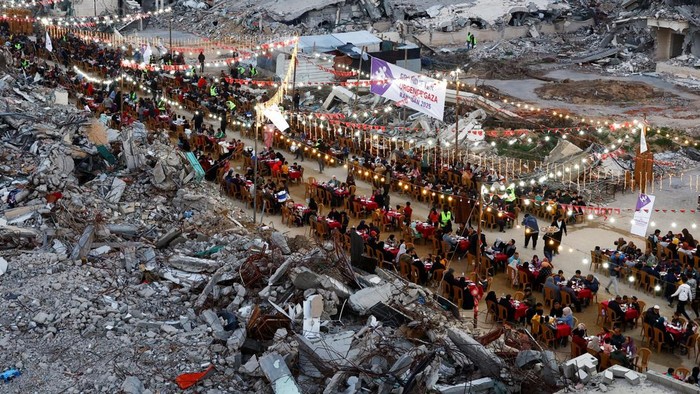 Palestinians break their fast by eating the Iftar meals during the holy month of Ramadan, near the rubble of buildings, amid a ceasefire between Israel and Hamas, in Rafah, in the southern Gaza Strip, March 1, 2025. REUTERS/Hatem Khaled     TPX IMAGES OF THE DAY