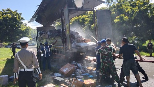 Petugas saat berupaya memadamkan api yang membakar trus boks bermuatan paket di Pelabuhan Gilimanuk, Kabupaten Jembrana, Bali, Minggu (2/3/2025).