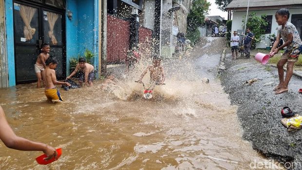 Banjir di Jalan Kemuning, Pejaten Timur, Jaksel menjadi wahanan dadakan bocah main air, Senin (3/3/2025).