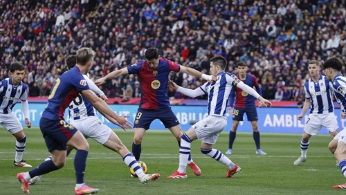 Barcelonas Robert Lewandowski (9) is challenged by Real Sociedads Igor Zubeldia during the Spanish La Liga soccer match between Barcelona and Real Sociedad at the Lluis Companys Olympic Stadium in Barcelona, Spain, Sunday, March 2, 2025. (AP Photo/Joan Monfort)