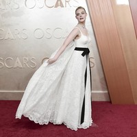 Spreading cape. Elle Fanning menggepakkan gaun putih Givenchy beraksen pita yang dilengkapi dekorasi menyerupai sayap.  (Foto: Richard Shotwell/Invision/AP)